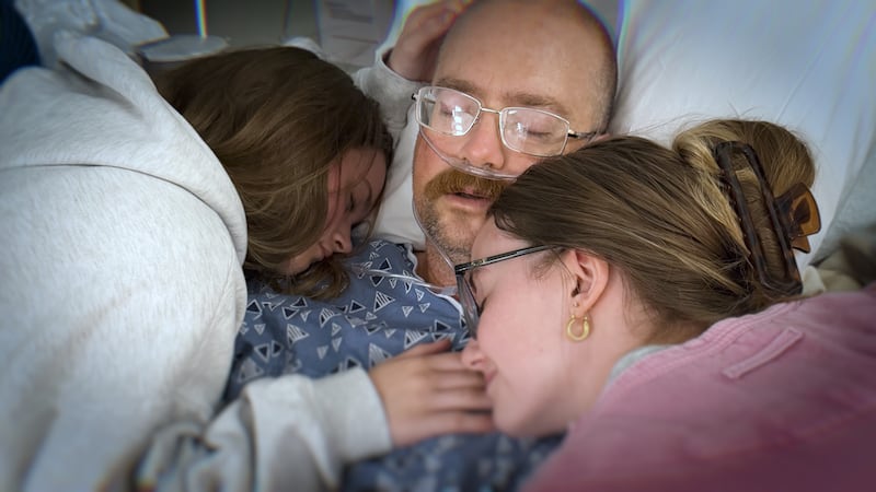 Jackson County Sheriff's Deputy Craig Scott surrounded by his daughters while recovering at...